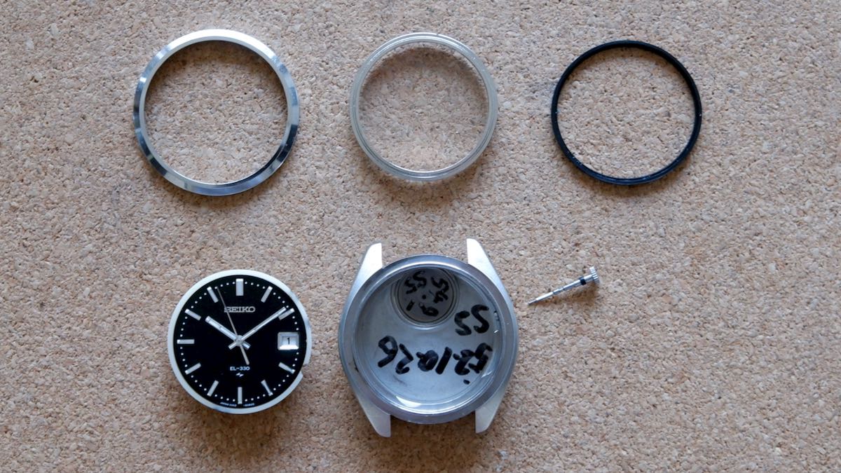 Showing the disassembled parts of a Seiko 3302-8080 watch.